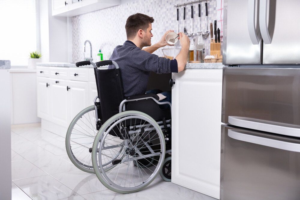 A Person in a Wheelchair is Pouring a Drink — Adaptive Care Pty Ltd In Sunshine, VIC