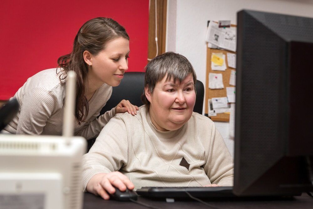 Two Women Are Engaged With a Computer — Adaptive Care Pty Ltd In Werribee, VIC