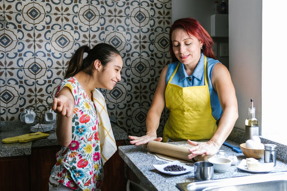 Woman in Yellow Apron Rolls Dough — Adaptive Care Pty Ltd In Sunshine, VIC