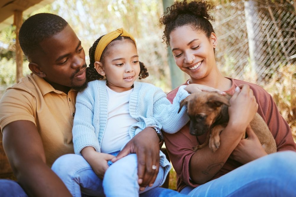 Happy family holding puppy ©PeopleImages.com - Yuri A