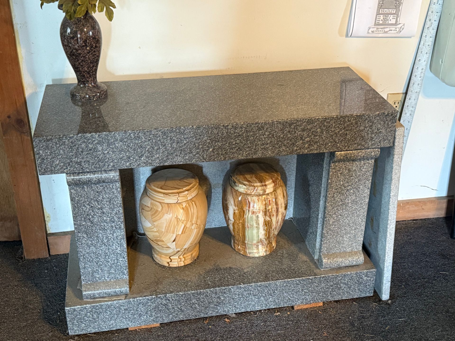 A table with two urns and a vase on it