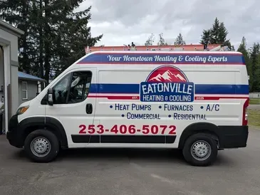 White Eatonville Heating & Cooling service van parked outdoors with red and blue signage and phone number 253-406-5072
