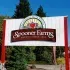Spokane Farms sign with red-and-white logo above a red brick archway and greenery