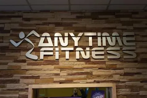 Anytime Fitness logo on a stone wall above a doorway