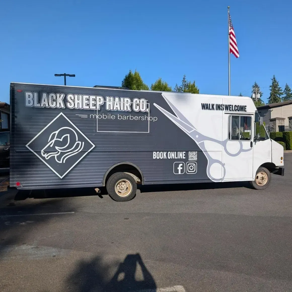 Black Sheep Hair Co. mobile salon van parked outdoors under a blue sky