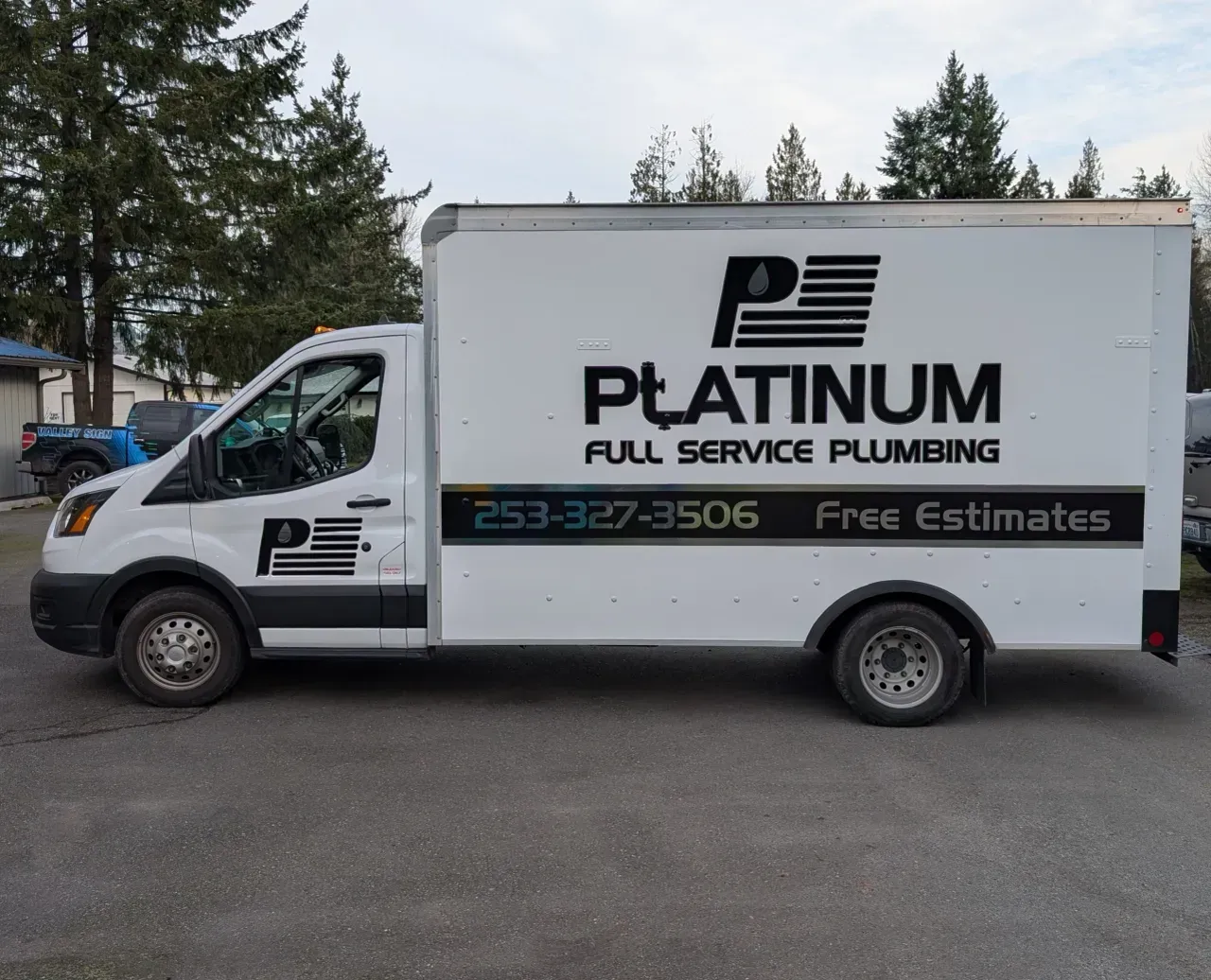 White Platinum Full Service Plumbing van parked outdoors with company logo and phone number on the side