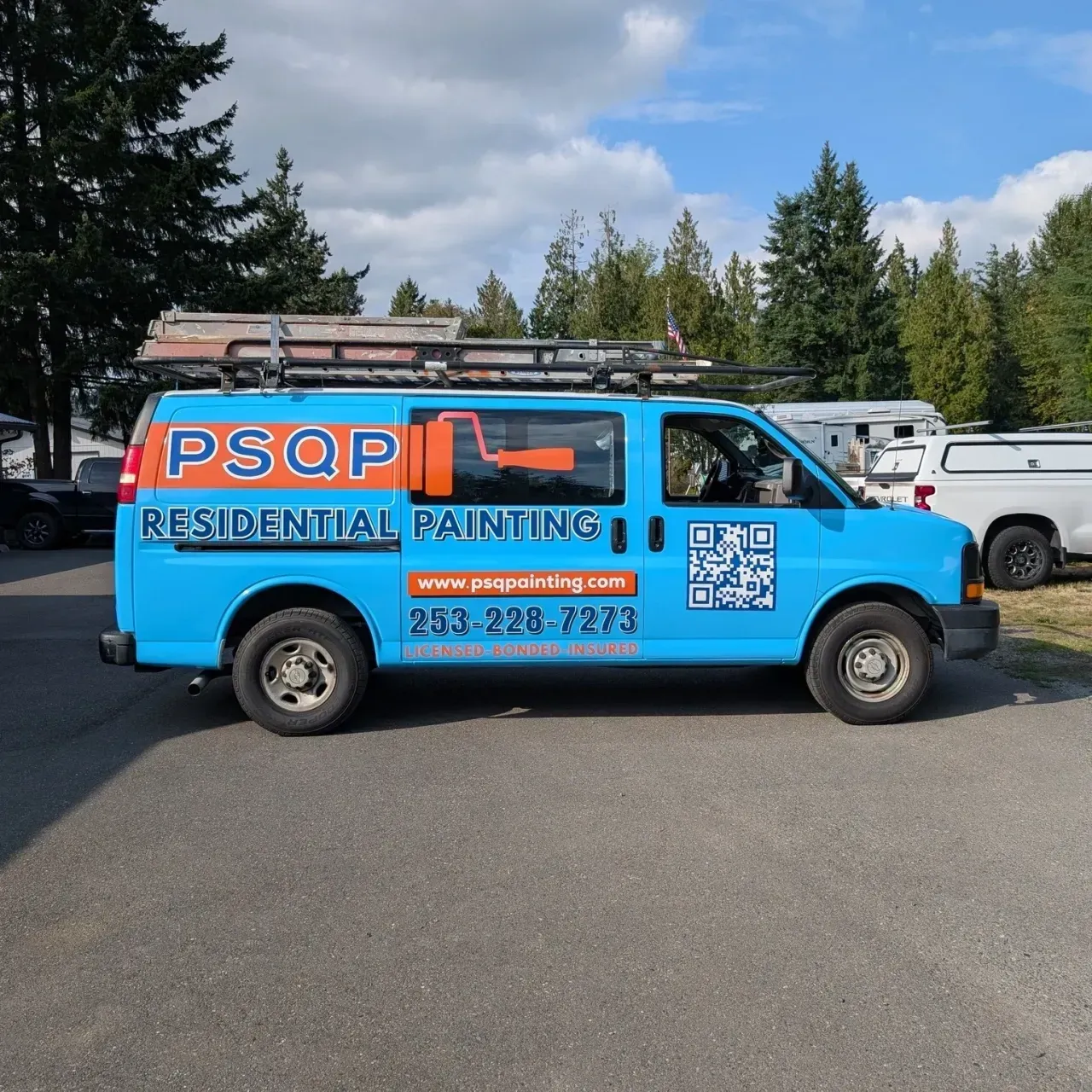 Blue PSQP residential painting van parked in a lot, with ladder rack and company contact info on the side.