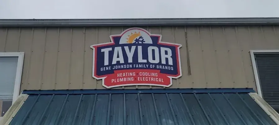 Taylor Plumbing & Heating sign on a building exterior under a dark awning.