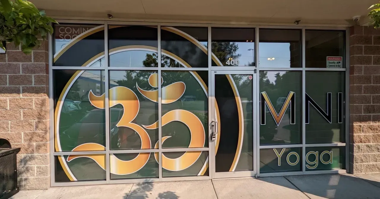 Storefront window with a large orange “350” logo and “YMN Yoga” sign beside it.