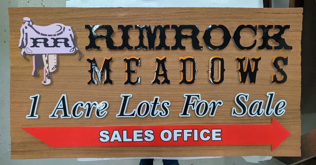 Sign for Rimrock Meadows, “1 Acre Lots For Sale,” with red sales office arrow