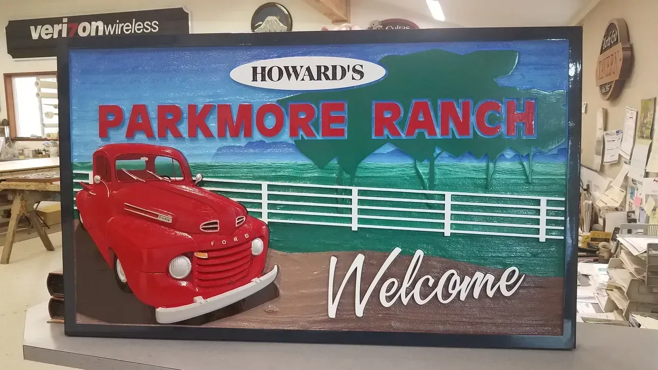 Howard's Parkmore Ranch welcome sign with a red vintage car and white fence scene