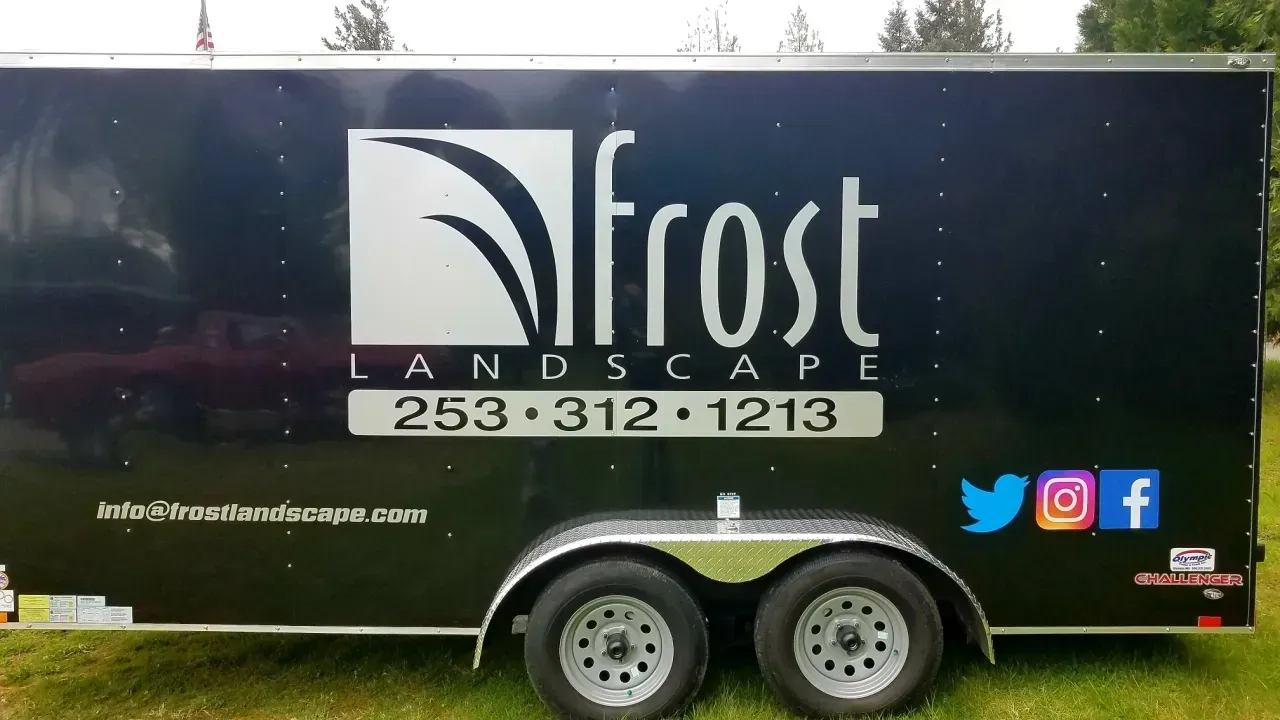 Black trailer with “Frost Landscape” logo, phone number, and social media icons parked outdoors