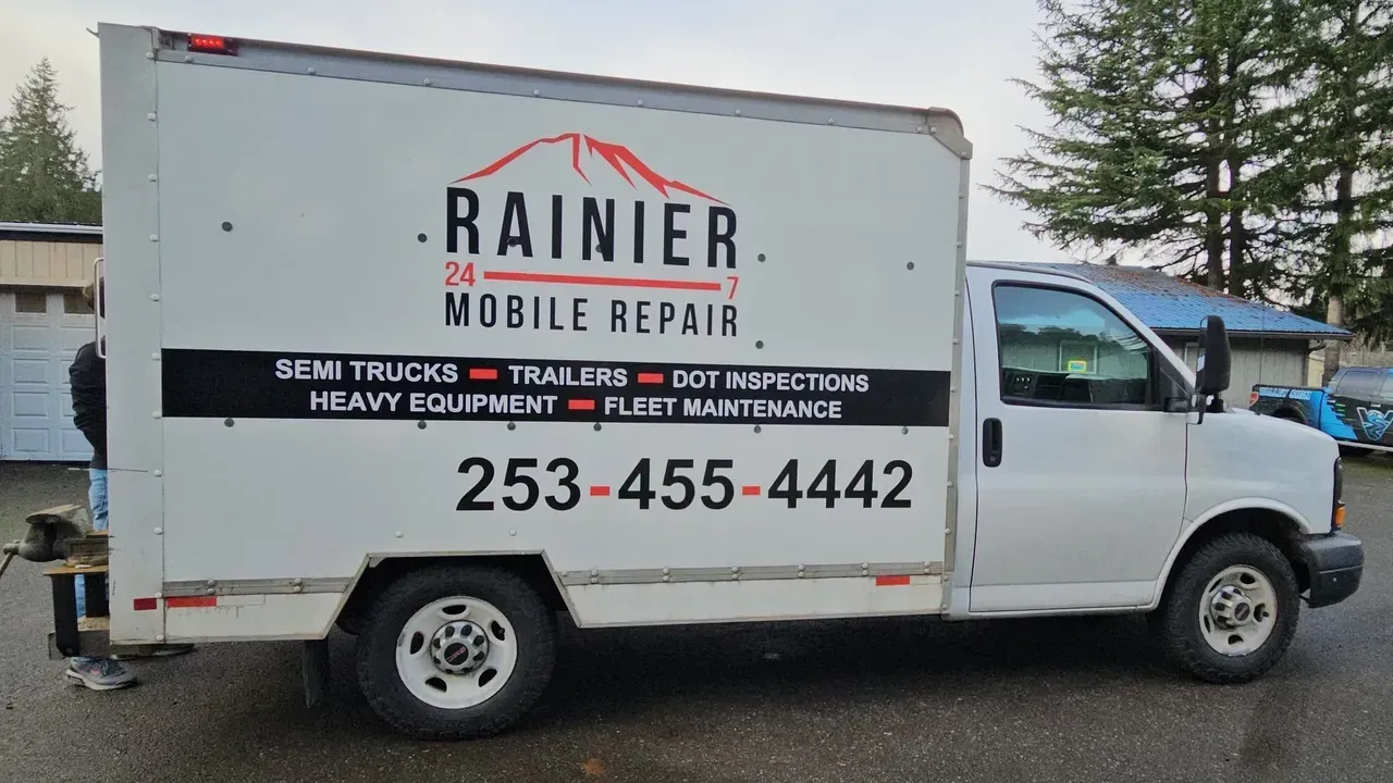 White Rainier Mobile Repair truck parked outdoors, side view with large logo and phone number 253-455-4442
