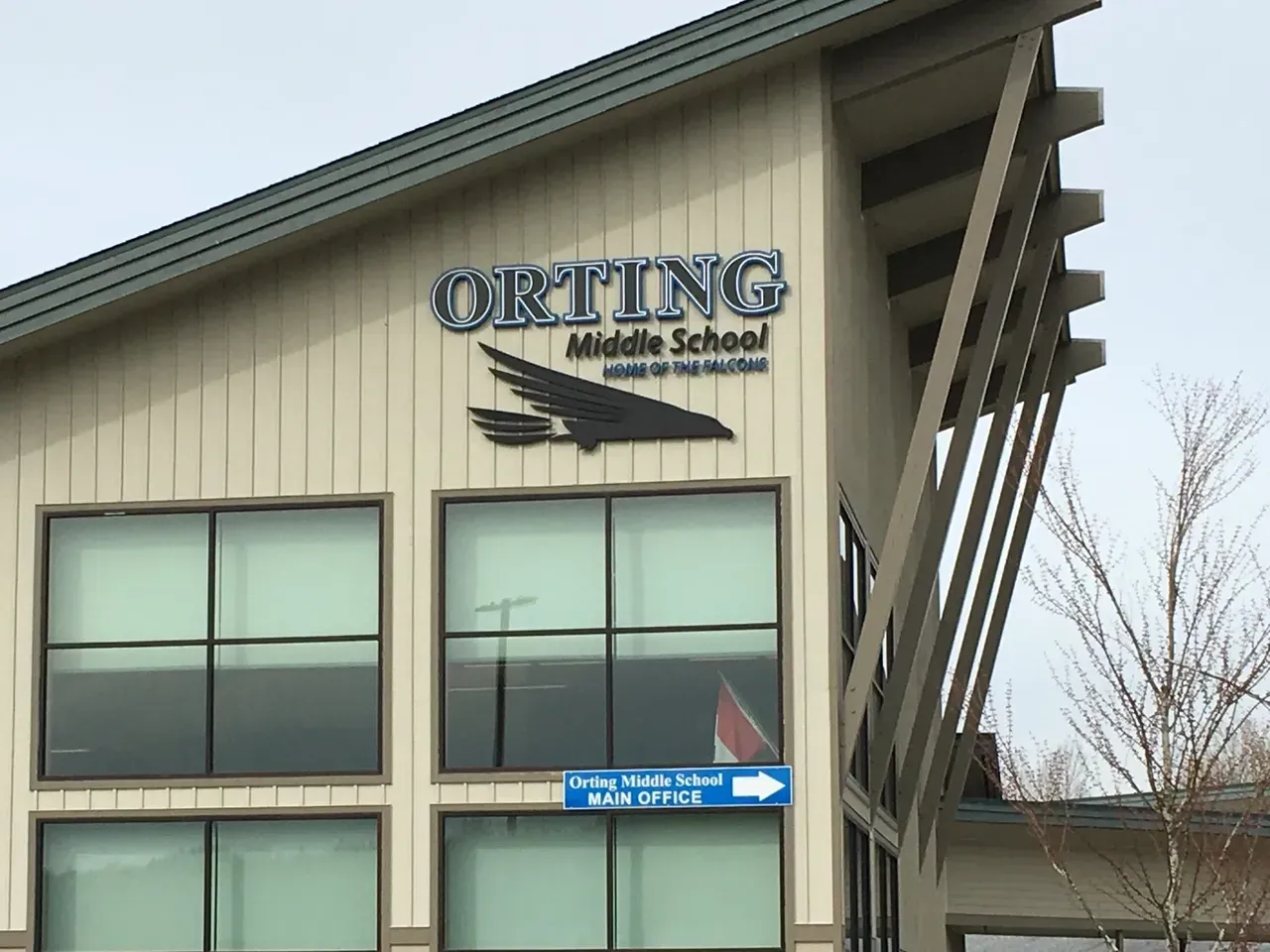 Okting Middle School building exterior with large windows and blue sky sign