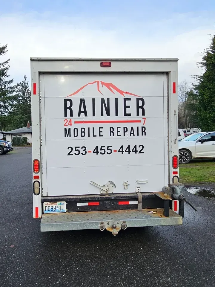 White Rainier 24 Mobile Repair truck viewed from the rear in a parking lot.