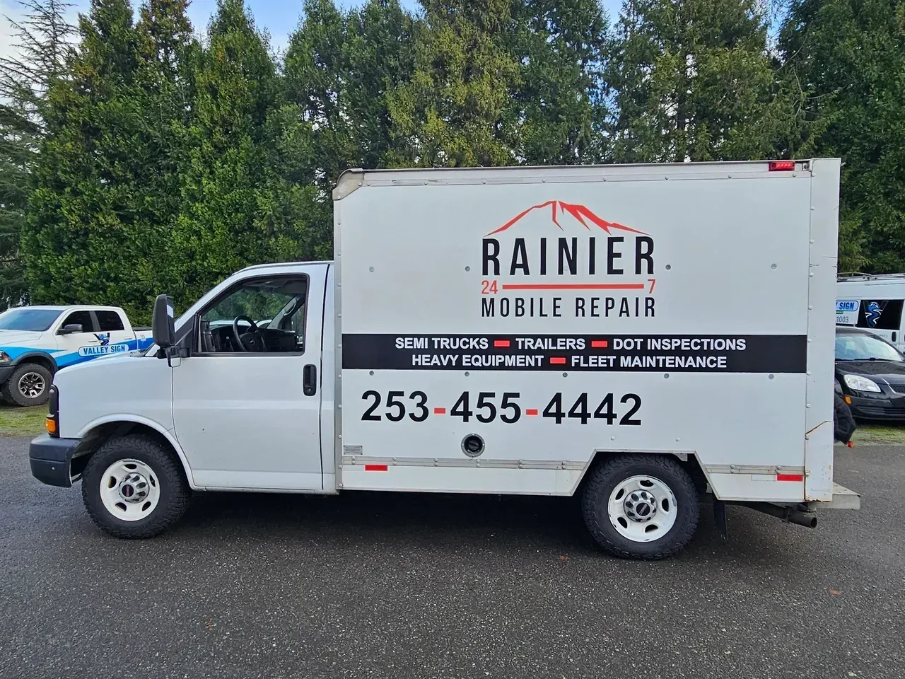 White Rainier Mobile Repair truck parked outdoors with service sign and phone number on the side