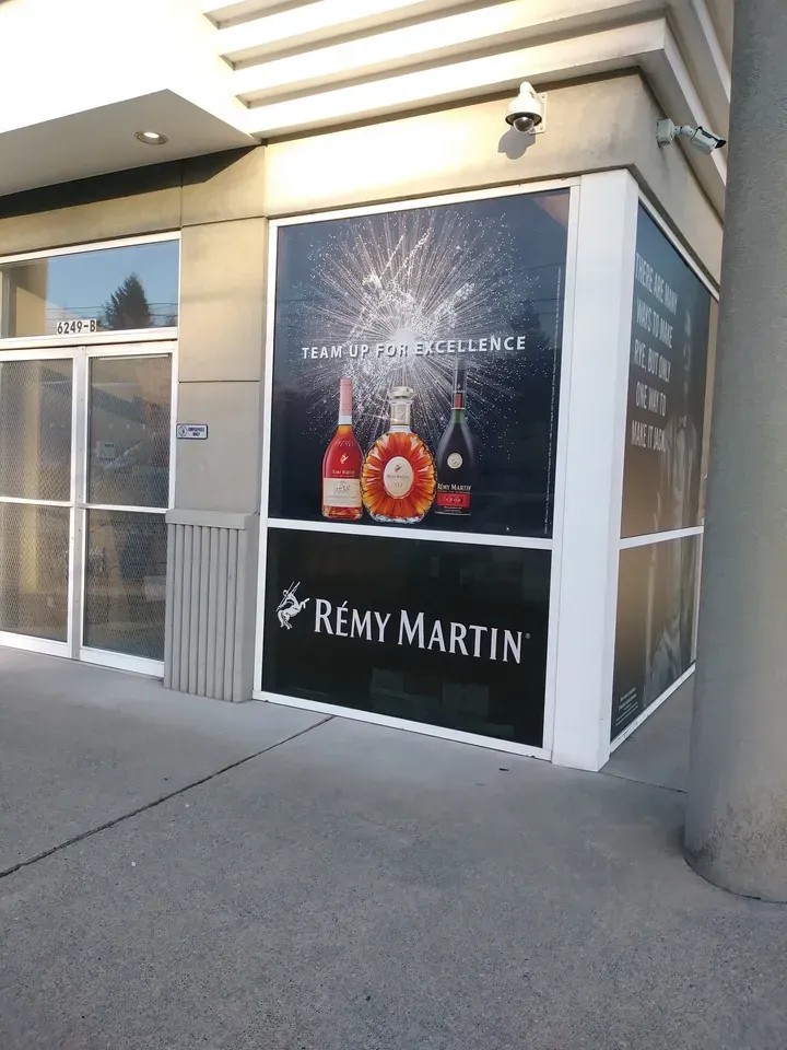 Rémy Martin storefront poster on a building exterior with bottles displayed