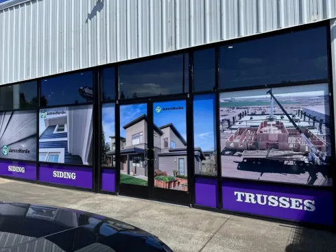 Storefront windows with large industrial and aerial photos, purple signage, and the word “THUSSES” on the right
