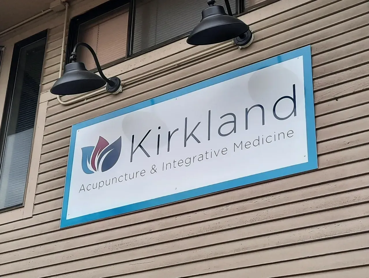 Kirkland sign with blue border on a building exterior created by Valley Sign