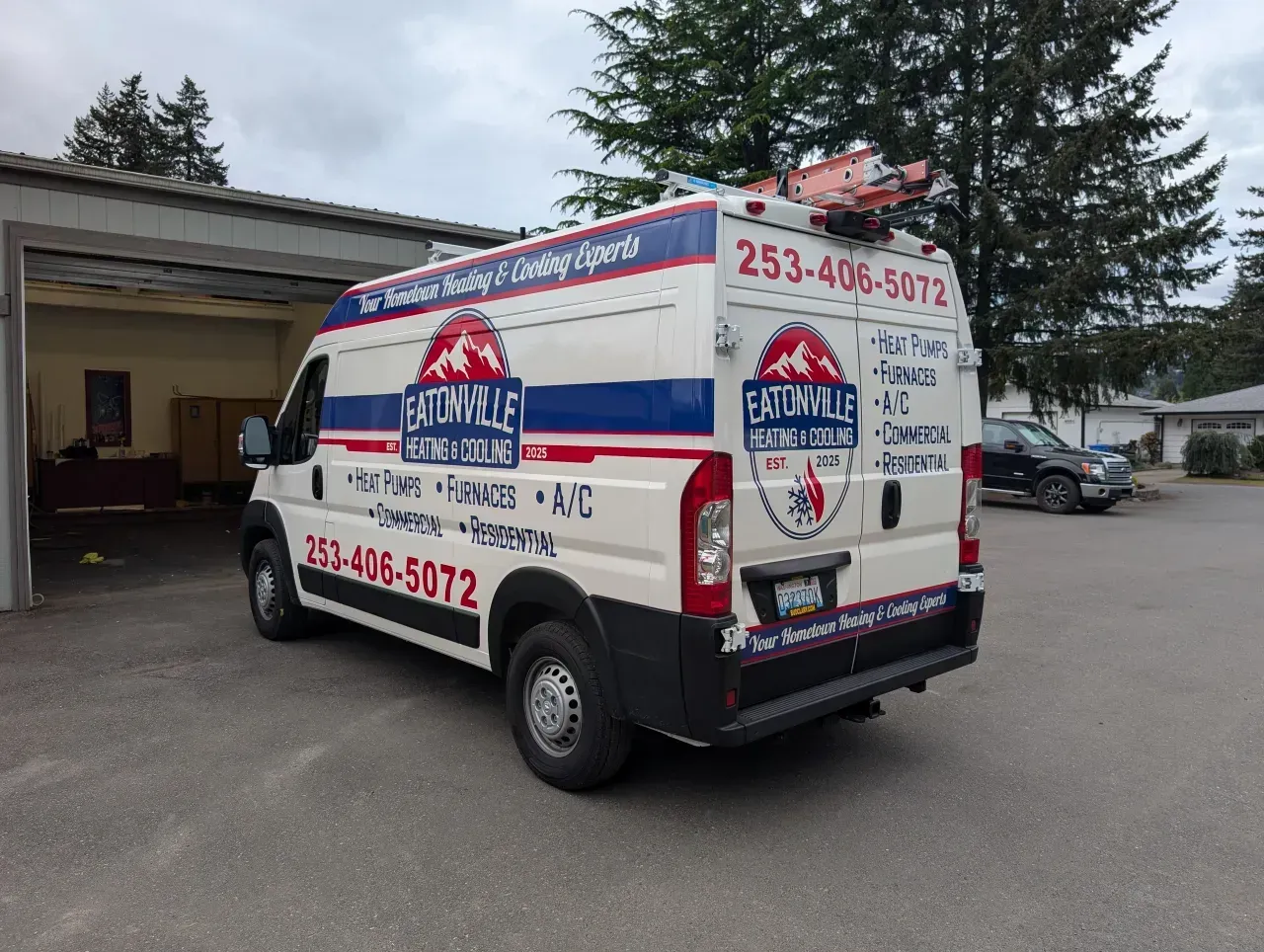 Red, white, and blue service van parked outside a garage with bold “Fast” branding and phone numbers.