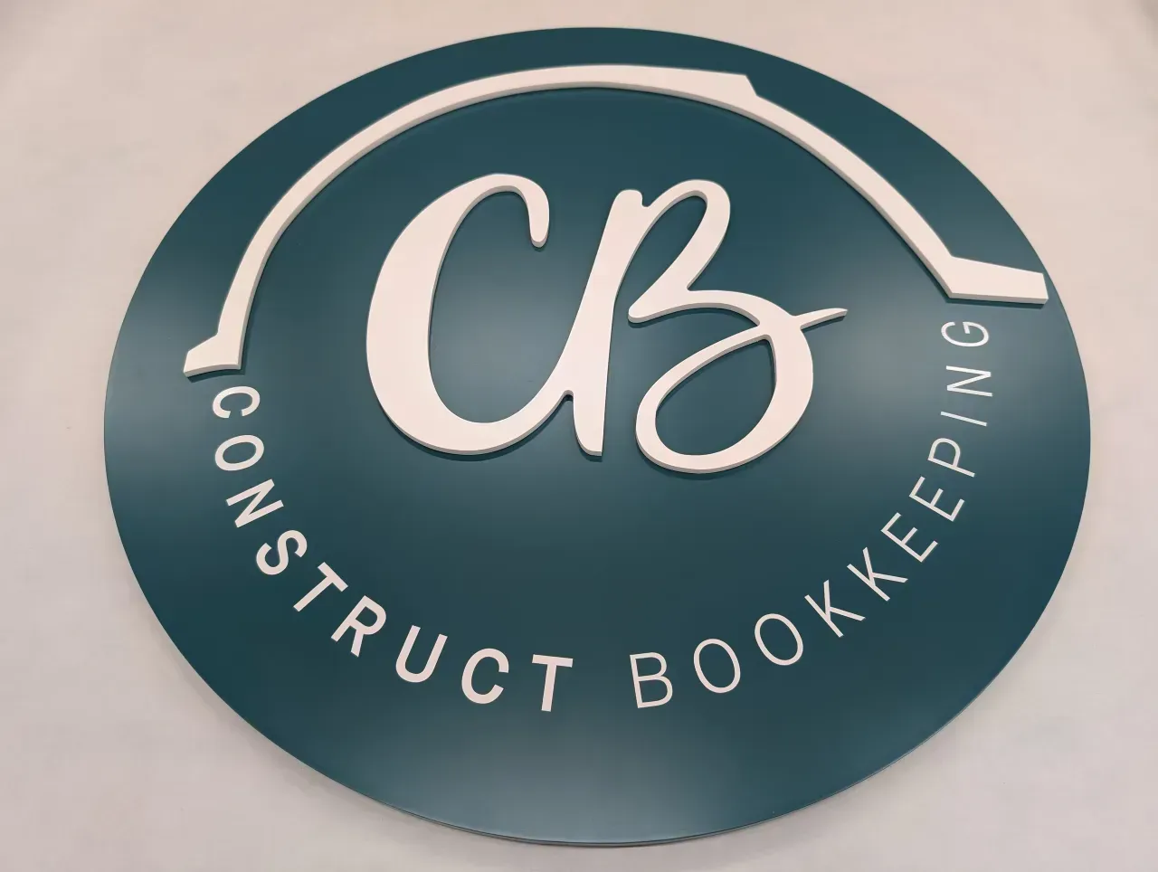 Circular teal logo with white “CB” and curved text reading “Construct Bookkeeping”