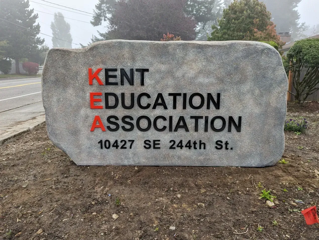 Stone sign for Kent Education Association, with red and black lettering at 10427 SE 244th St.