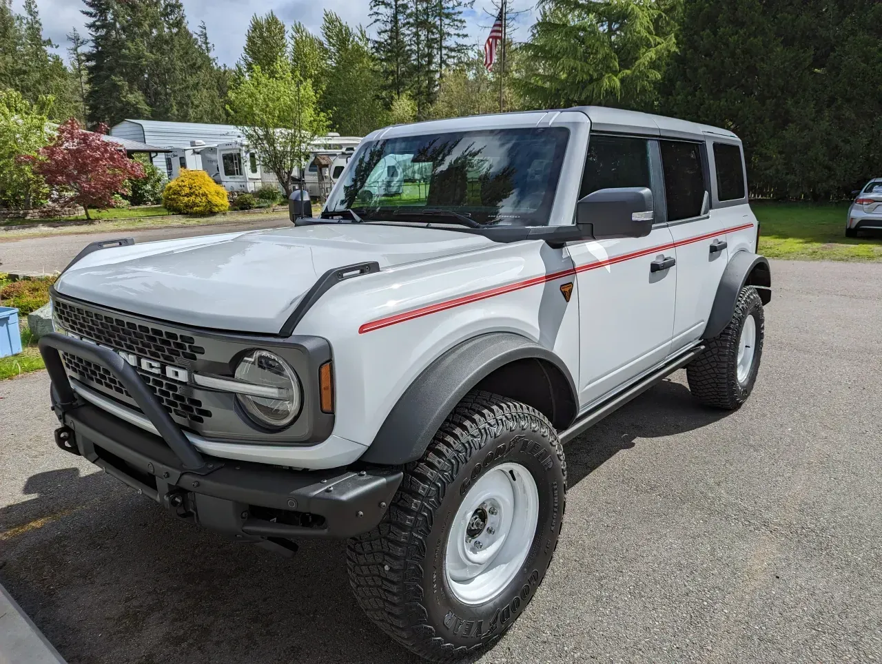 White vintage Ford Bronco parked outdoors on a residential street, angled front-left view