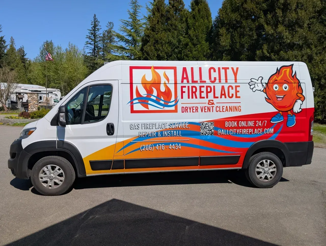 White All City Fireplace service van with flame logo parked outdoors near trees.