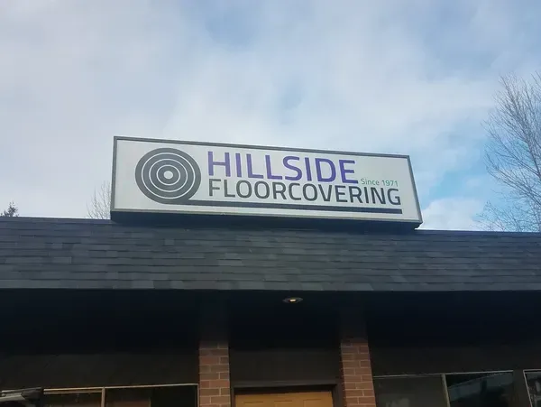 Valley Sign crafts custom commercial sign lettering by hand, with a gloved hand carefully carving raised letters from a sign panel in the workshop.