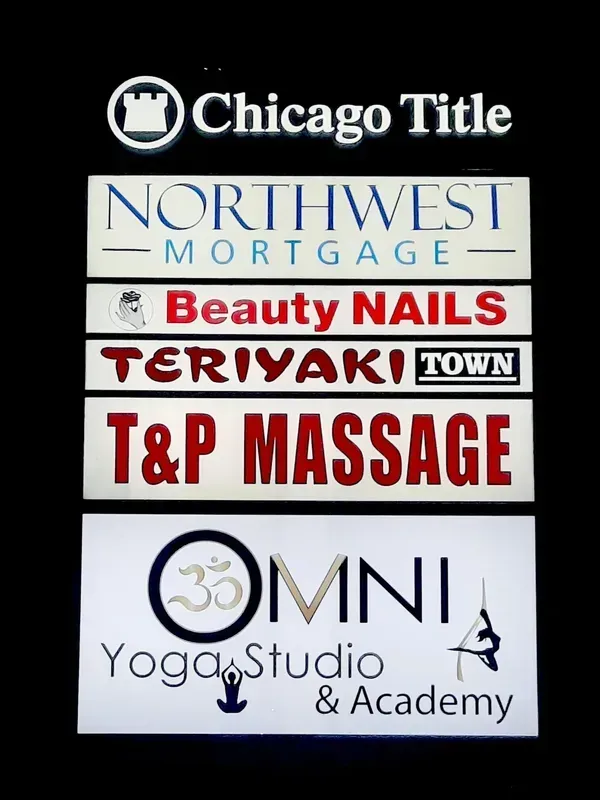 Business signboard listing Chicago Title, Northwest Mortgage, Beauty Nails, T&P Massage, and OMNI Yoga Studio & Academy
