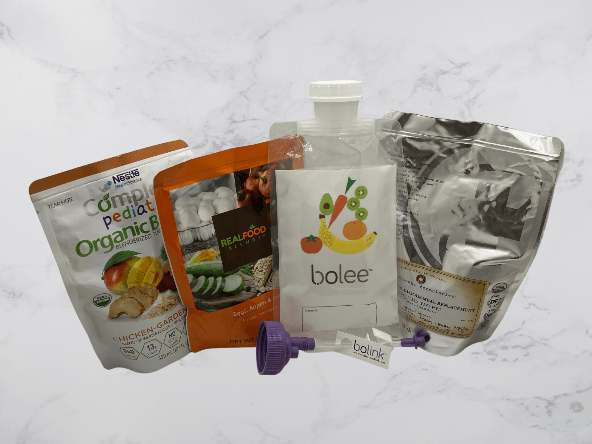 Bolee Bag and Bolink Large Cap in front of commercial tube feeding nutrition pouches