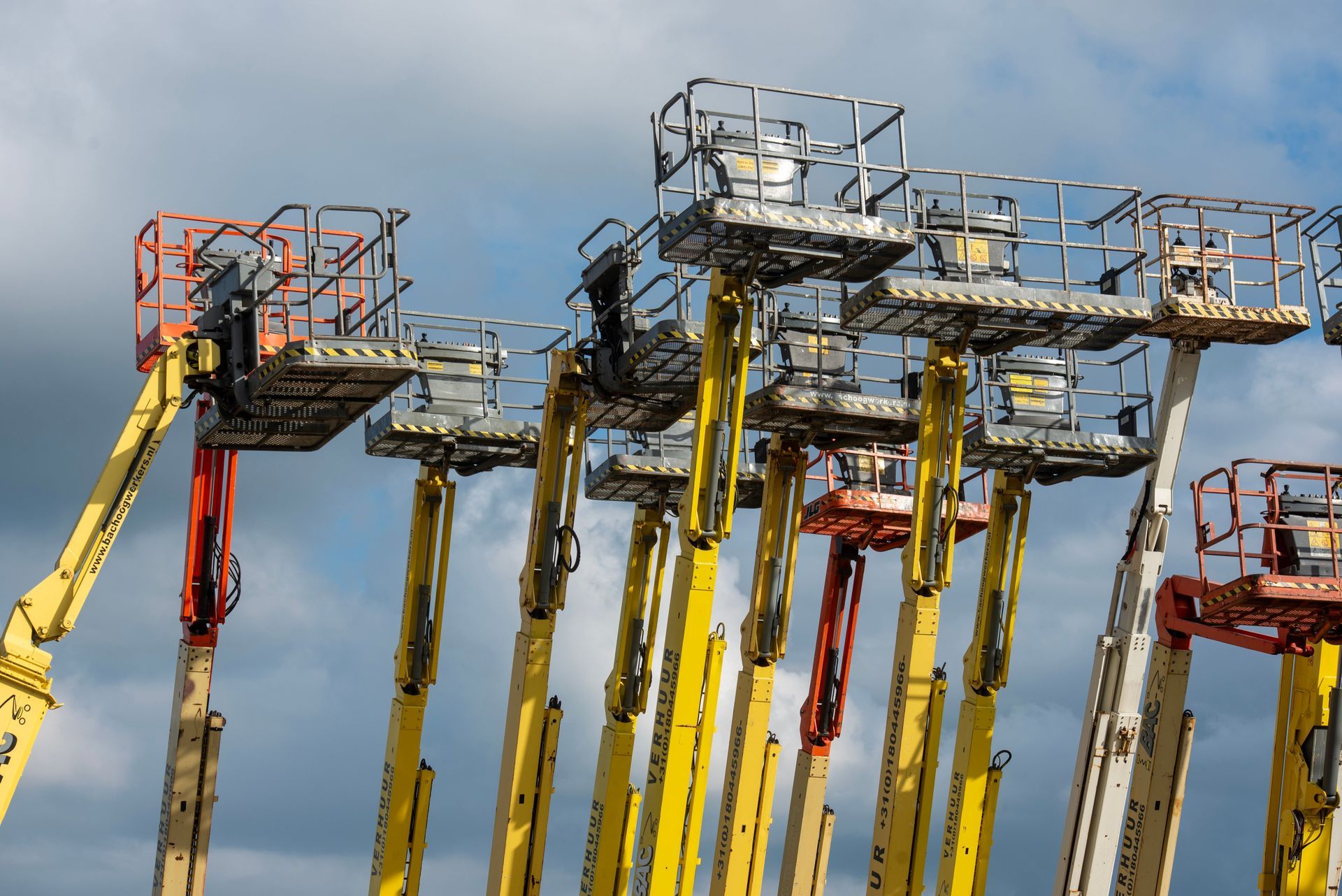 Boom lifts with their baskets raised, one of the lift types we certify