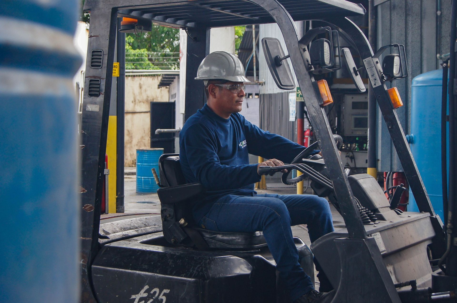 Forklift operator in a hard hat seated at the controls during operator certification training