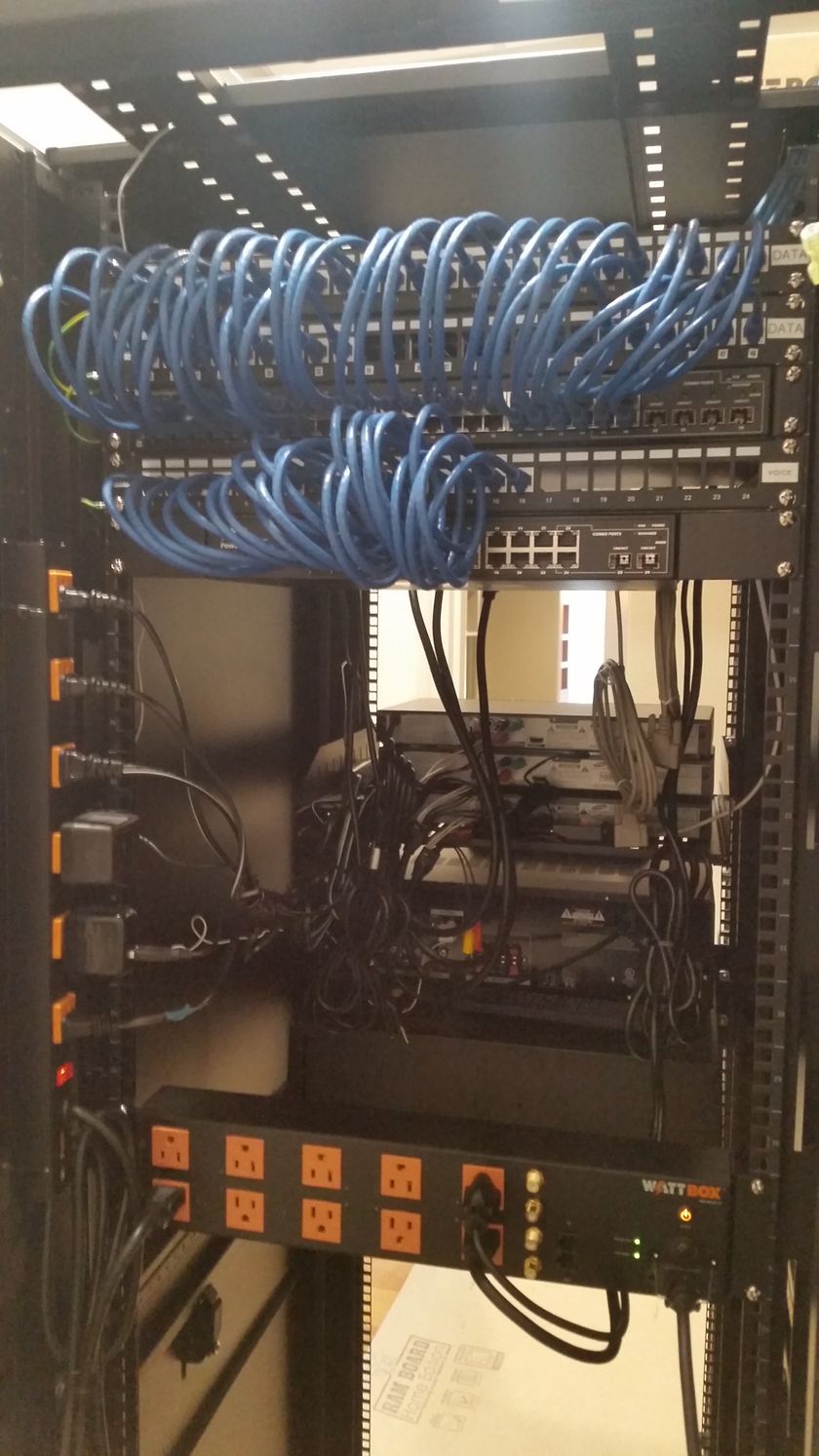 A server rack with a lot of wires hanging from it