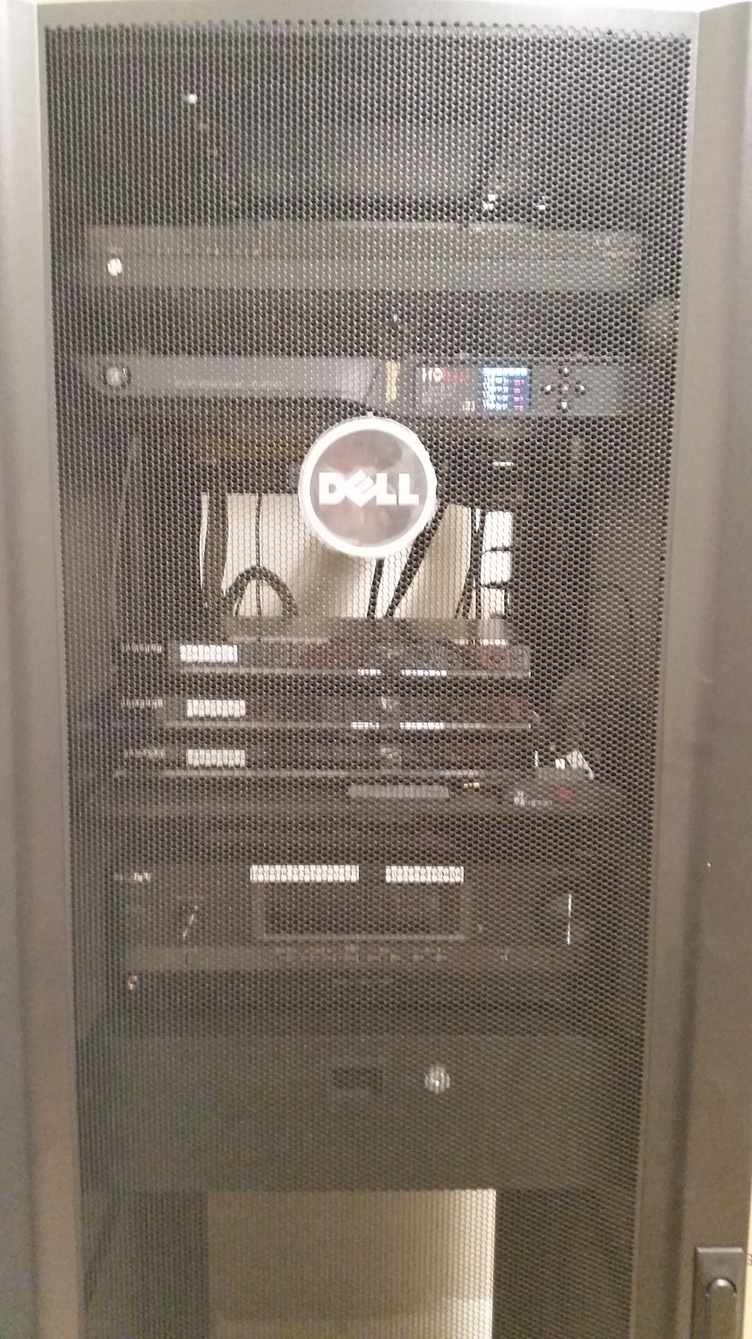 A dell server is sitting in a rack in a server room.
