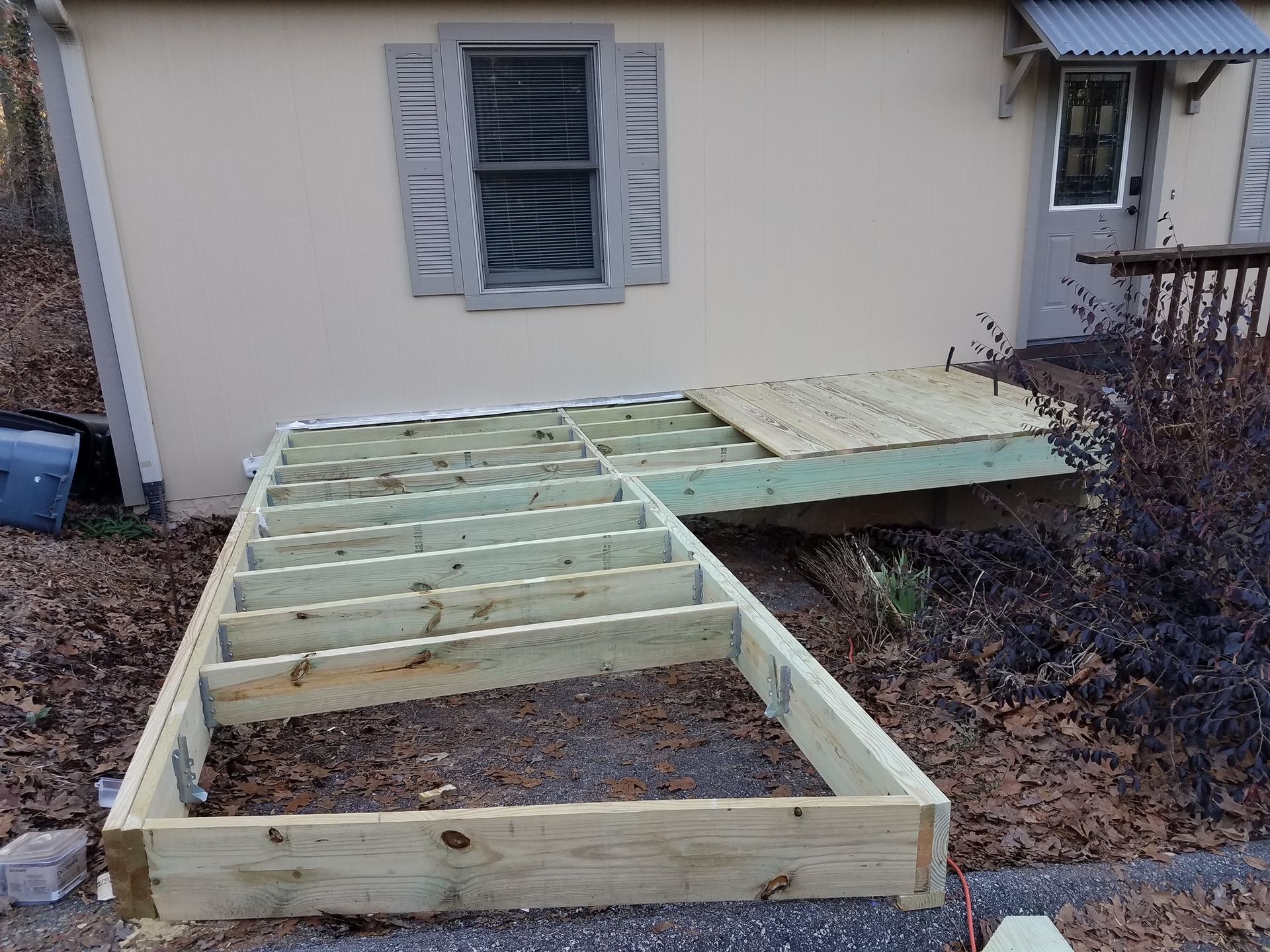 A wooden deck is being built in front of a house.