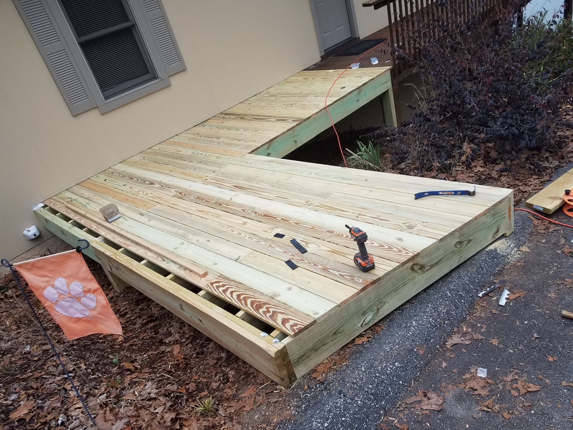 A wooden deck is being built in front of a house.