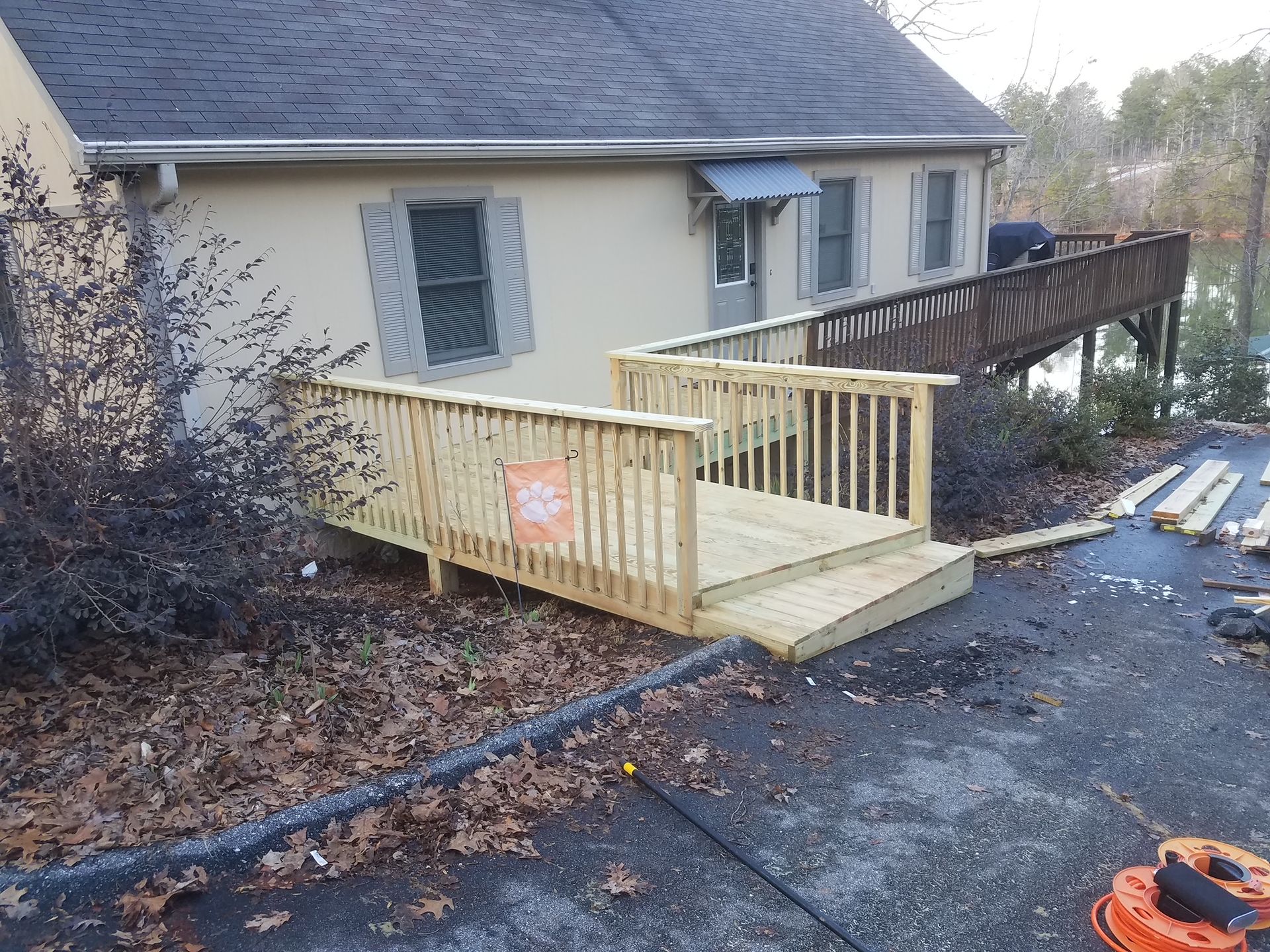 A wooden deck is being built in front of a house.