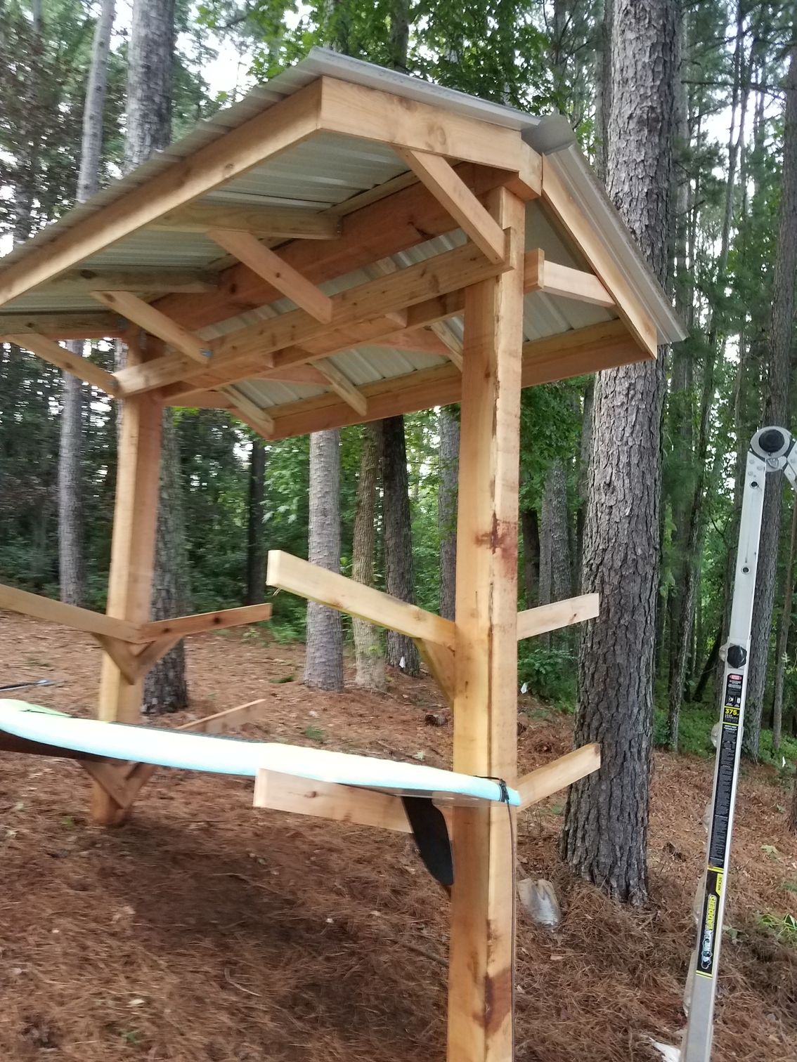 A wooden structure in the middle of a forest with a ladder next to it