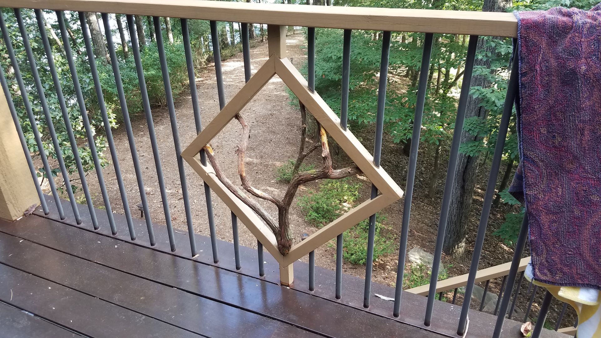A purple blanket is hanging on a railing on a deck