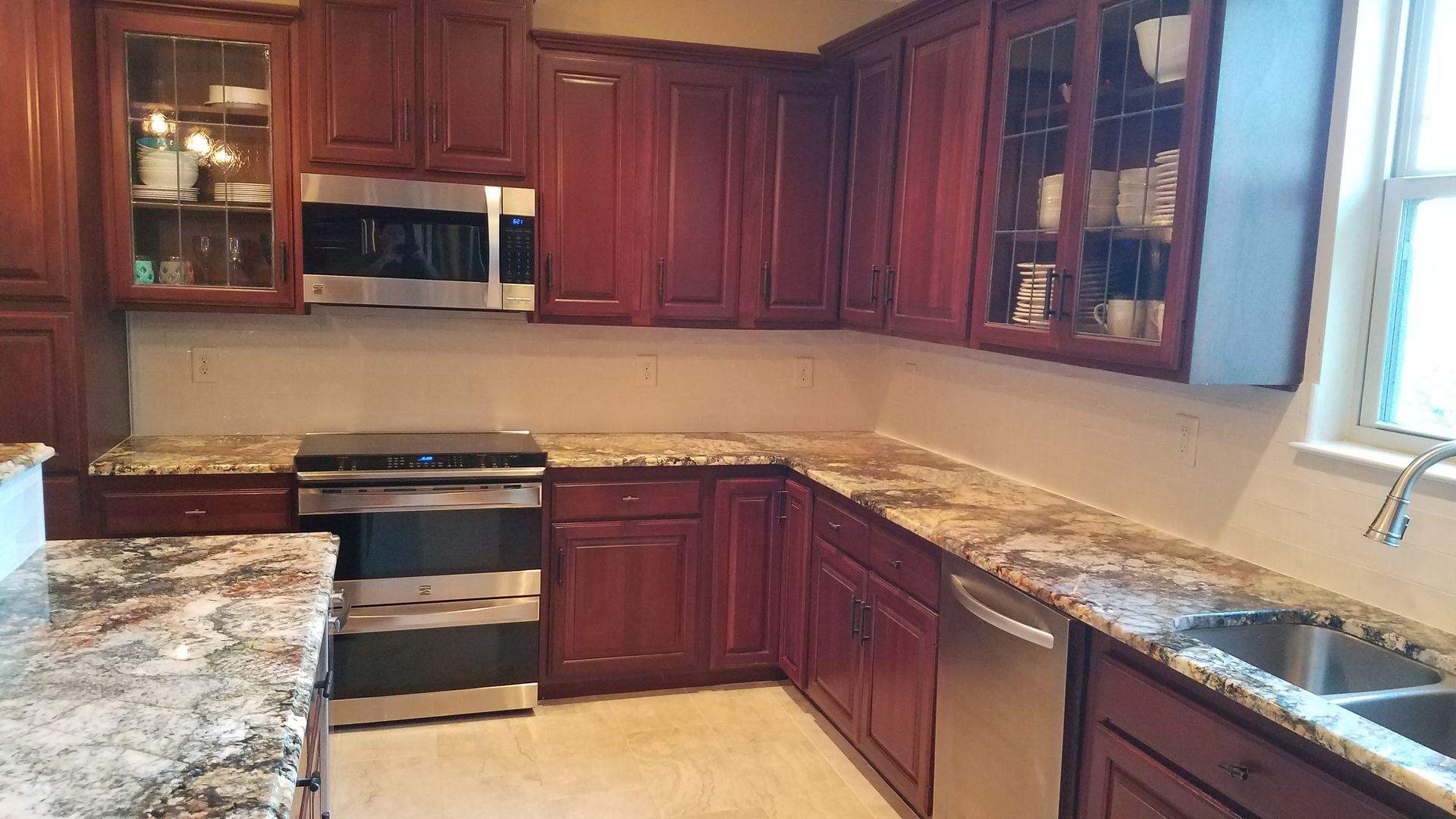 A kitchen with stainless steel appliances , granite counter tops , and wooden cabinets.