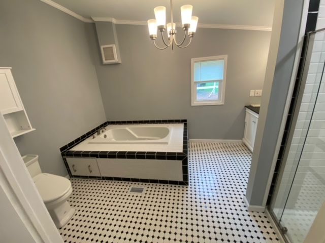 A bathroom with a jacuzzi tub and a toilet