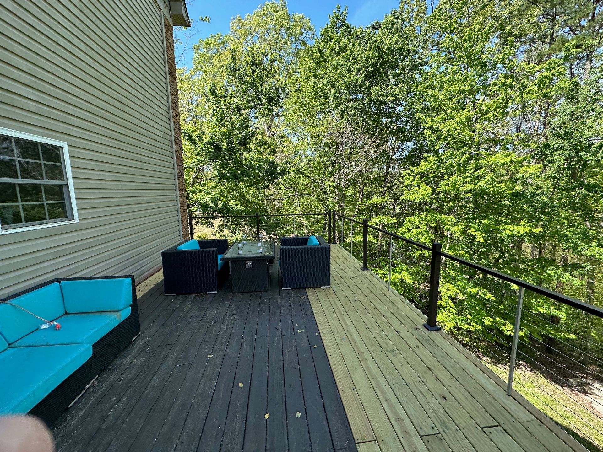A wooden deck with a couch and chairs on it
