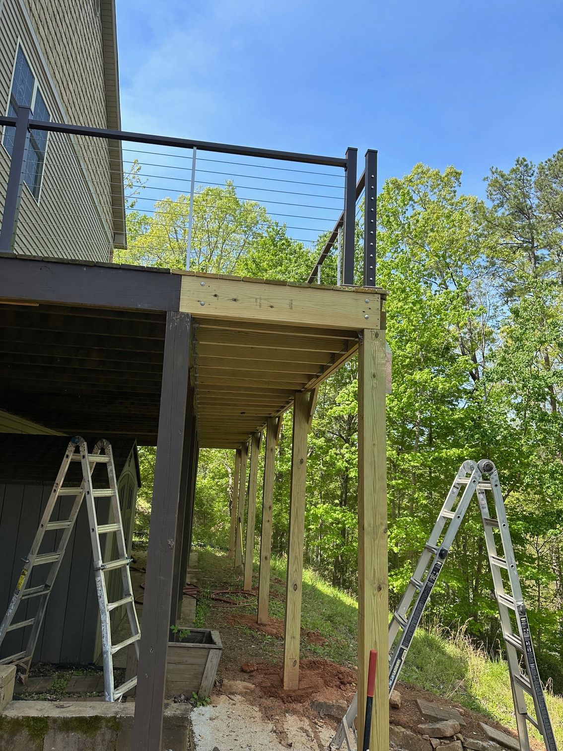 A wooden deck is being built on the side of a house.