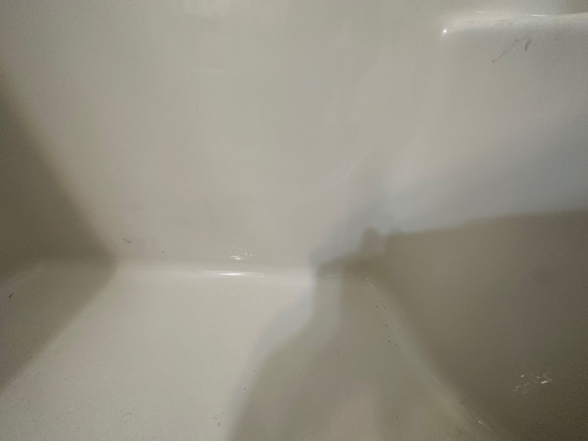 A close up of a white sink with water coming out of it.