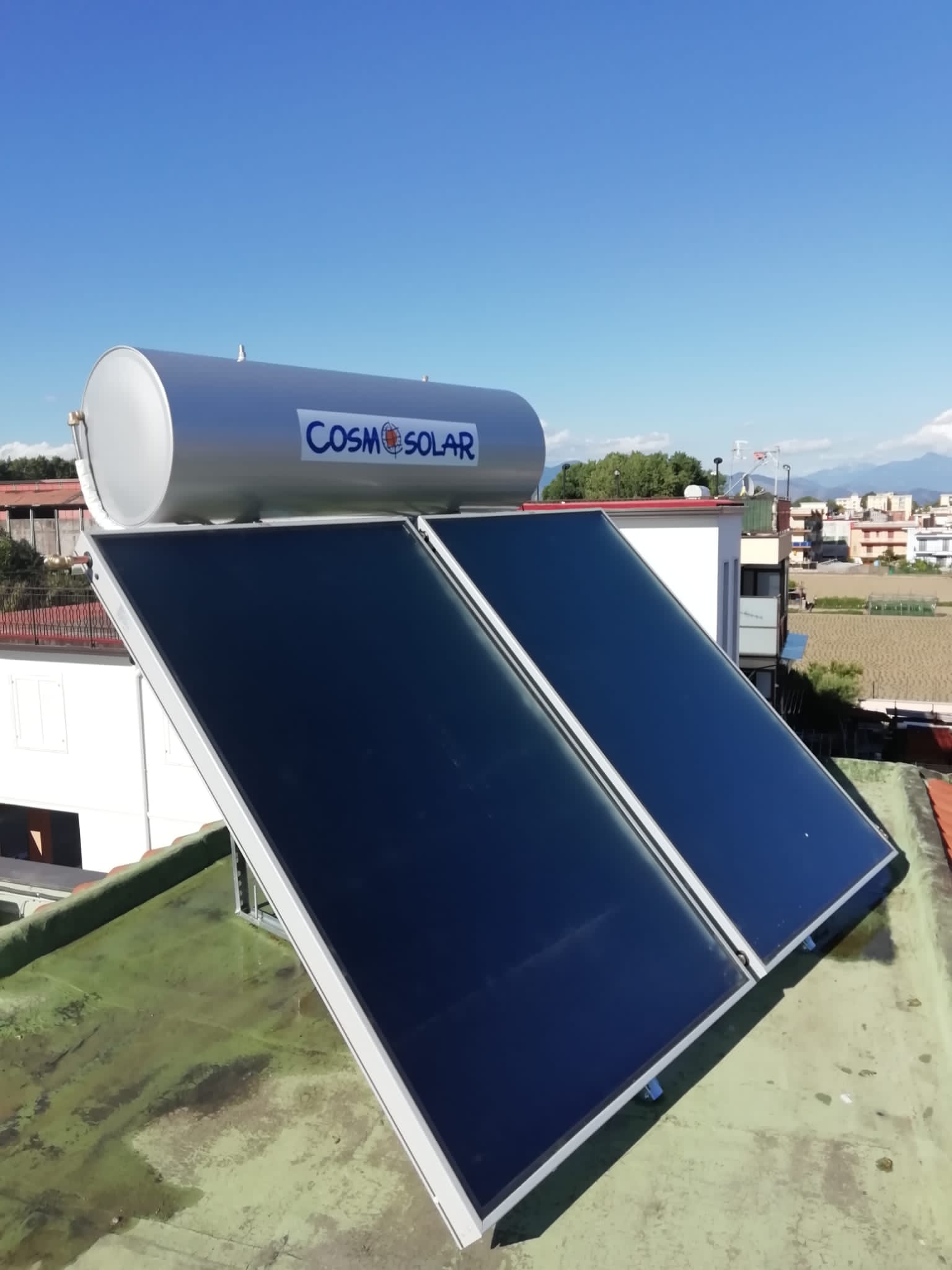 Uno scaldabagno solare è posizionato in cima a un tetto.