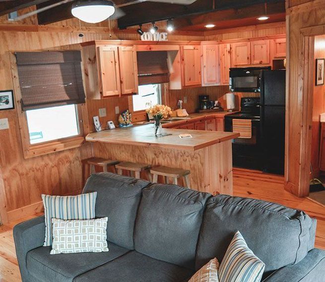 A living room with a couch and a kitchen in the background