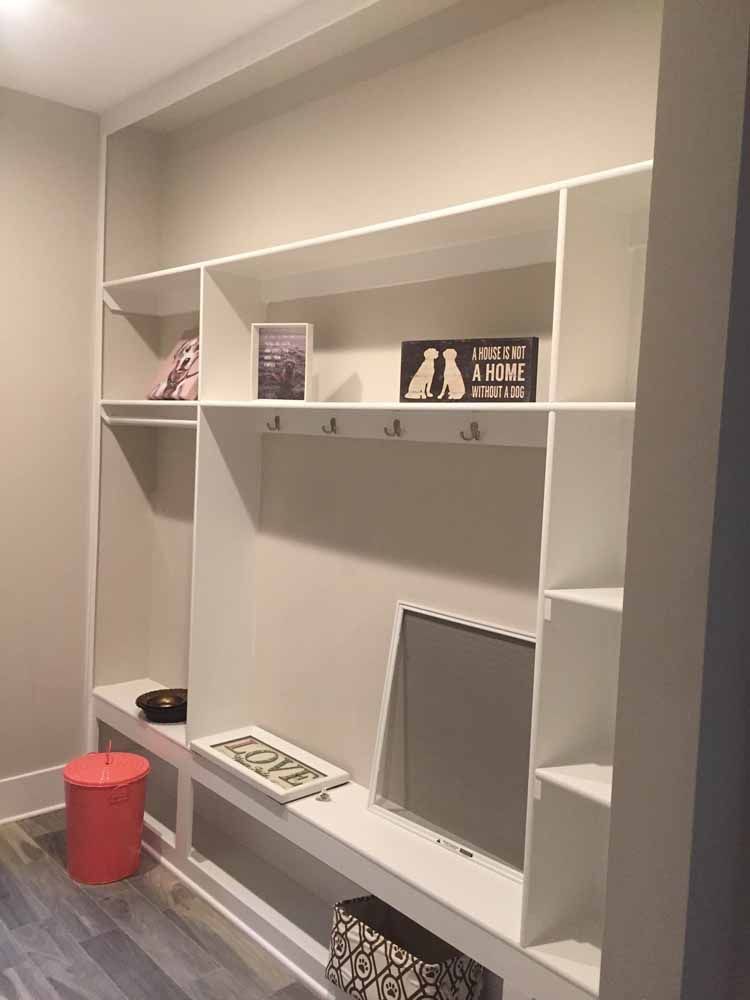 A room with a lot of shelves and a tv on the wall.