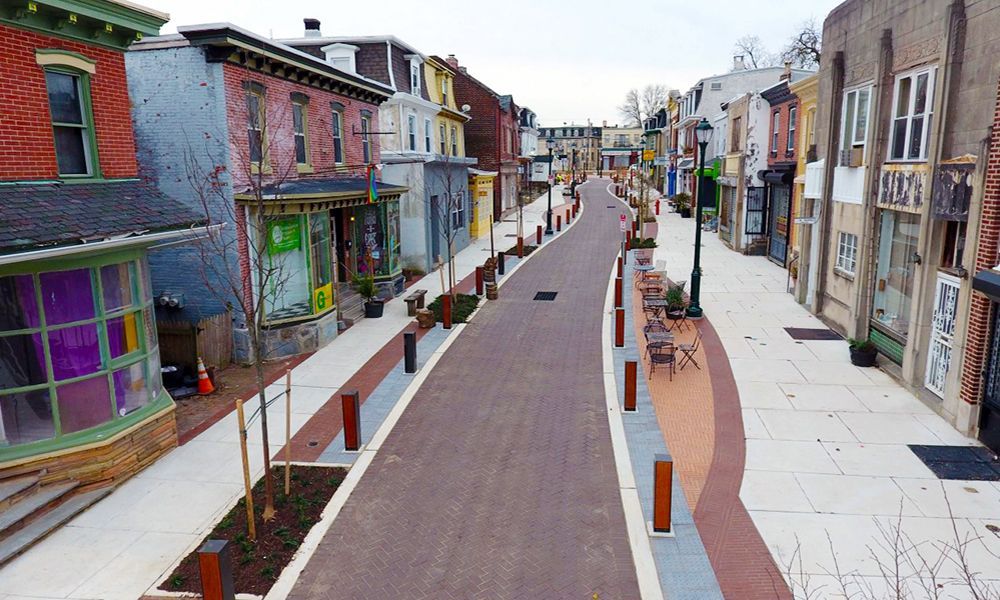 Empty brick-paved street lined with colorful buildings and storefronts