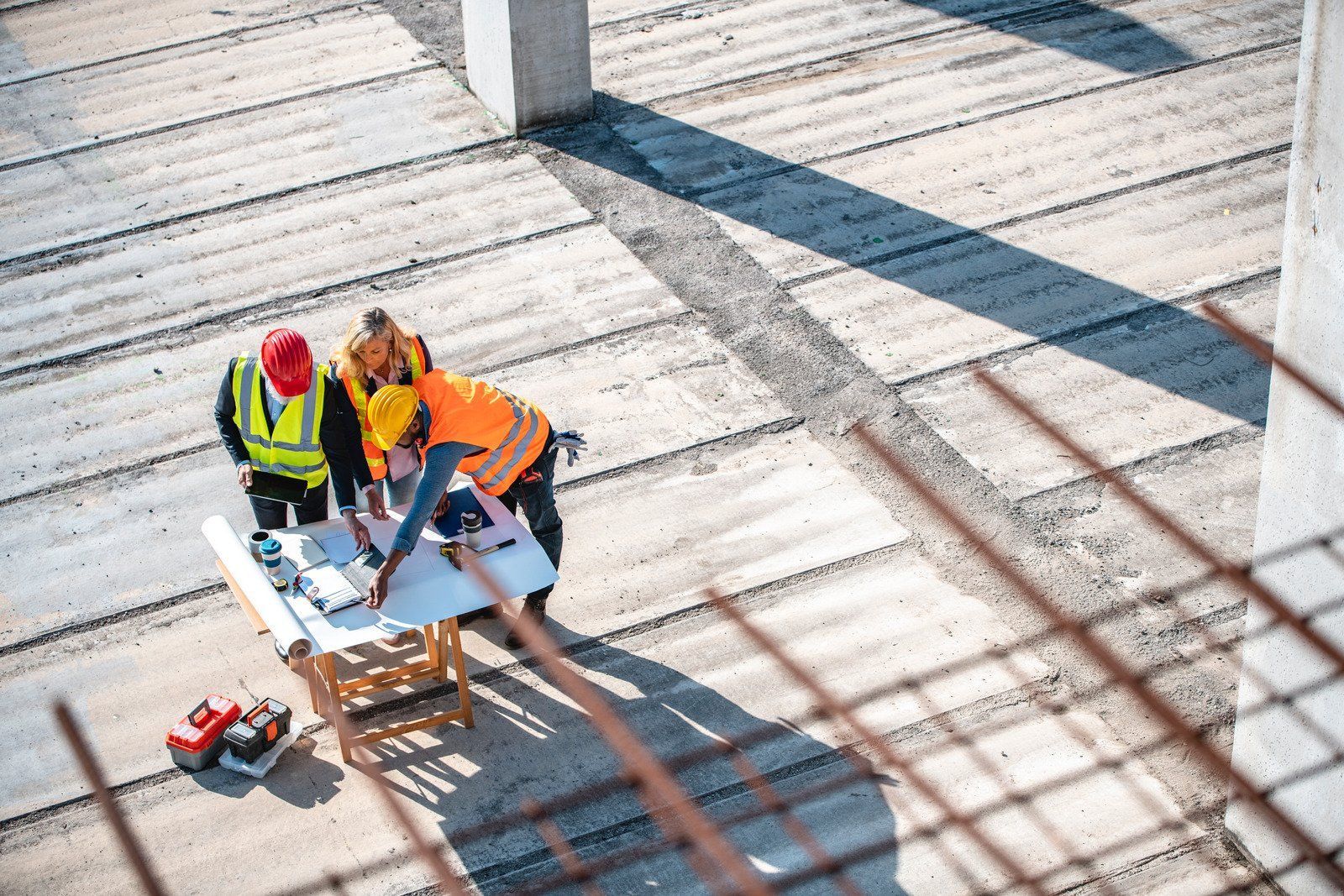 Construction workers examining blueprints on a building site.